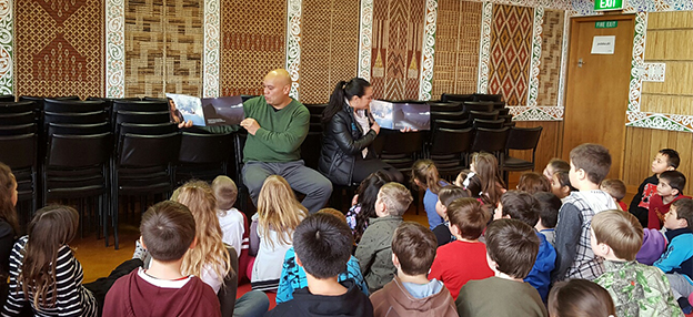 From left, Paddy Daintith and Tory Weatherall reading Māori and English versions of a story to the students of Bluff Community School. 