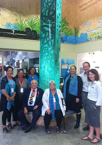 Māhaki whānau (Left to right) Marie Mahuika-Forsyth, Maria Russell, Rachael Forsyth, (seated) Richard Wallace and Barbara Vaea, Susan Wallace with DOC Managers Wayne Costello and Jo MacPherson with “Te Mata o te whenua,” the pou which anchors the space.
