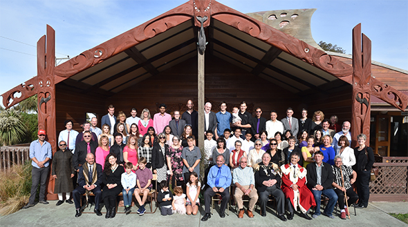 New citizens and whānau in front of the wharenui.