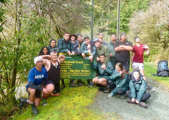 Rakatahi in front of the Hollyford Track sign. 