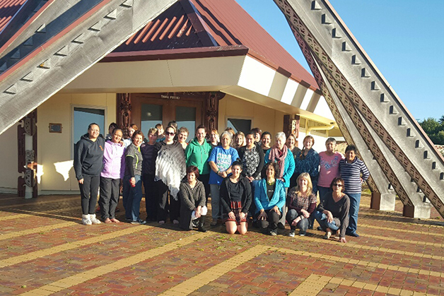 The group of weavers standing outside the marae. 